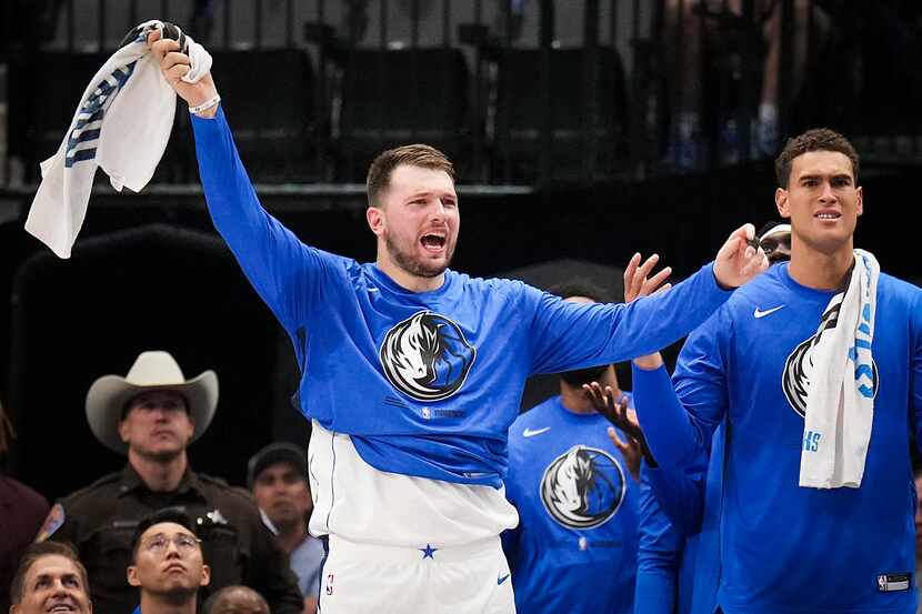 Dallas Mavericks guard Luka Doncic (left)nreacts to a call from the bench during the first...
