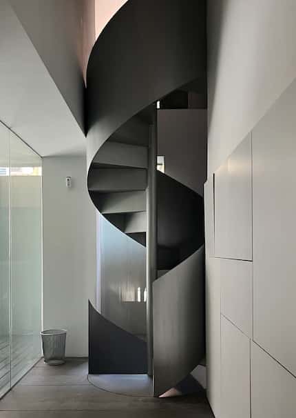A spiral staircase links floors at the Madrid office of Nieto Sobejano Arquitectos.
