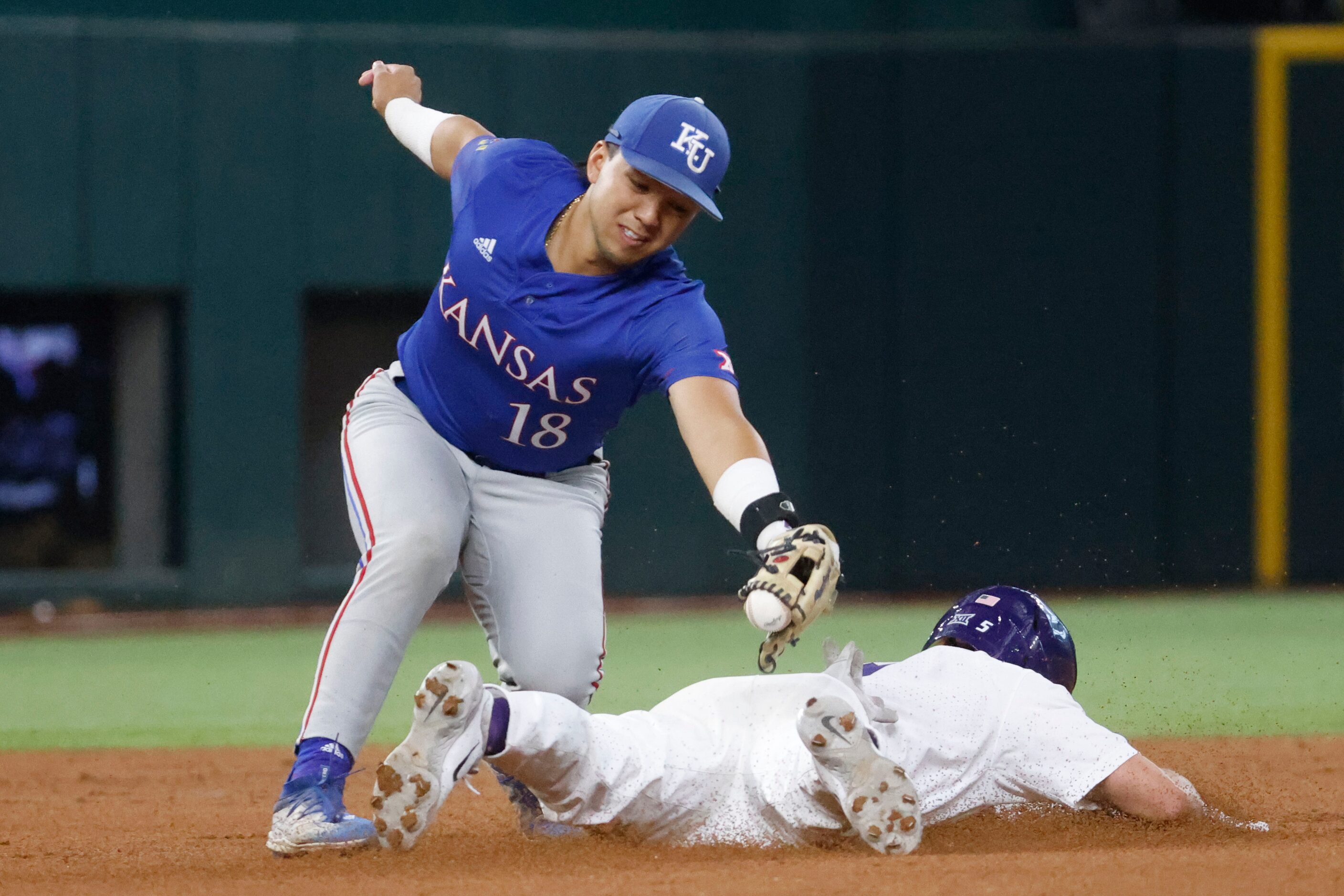 Kansas infielder Kodey Shojinaga (18) tags out Kansas St. outfielder Brendan Jones during...