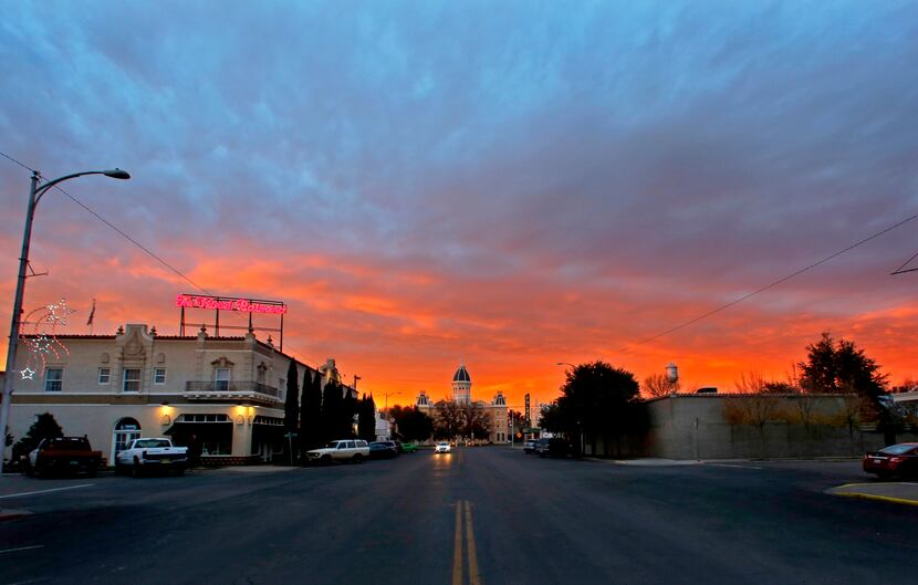 The sun sets over Hotel Paisano and the Presidio County Courthouse in Marfa, Texas. (Guy...