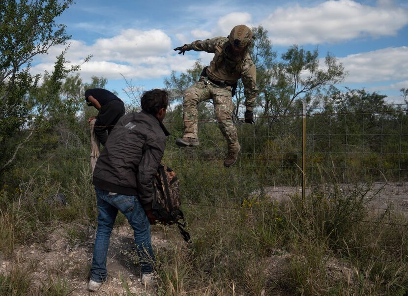 A Texas DPS special agent jumps a fence after catching unauthorized migrants from Honduras...