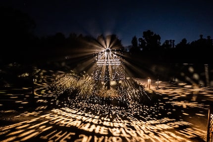 An illuminated display outdoors lights up the space at night.