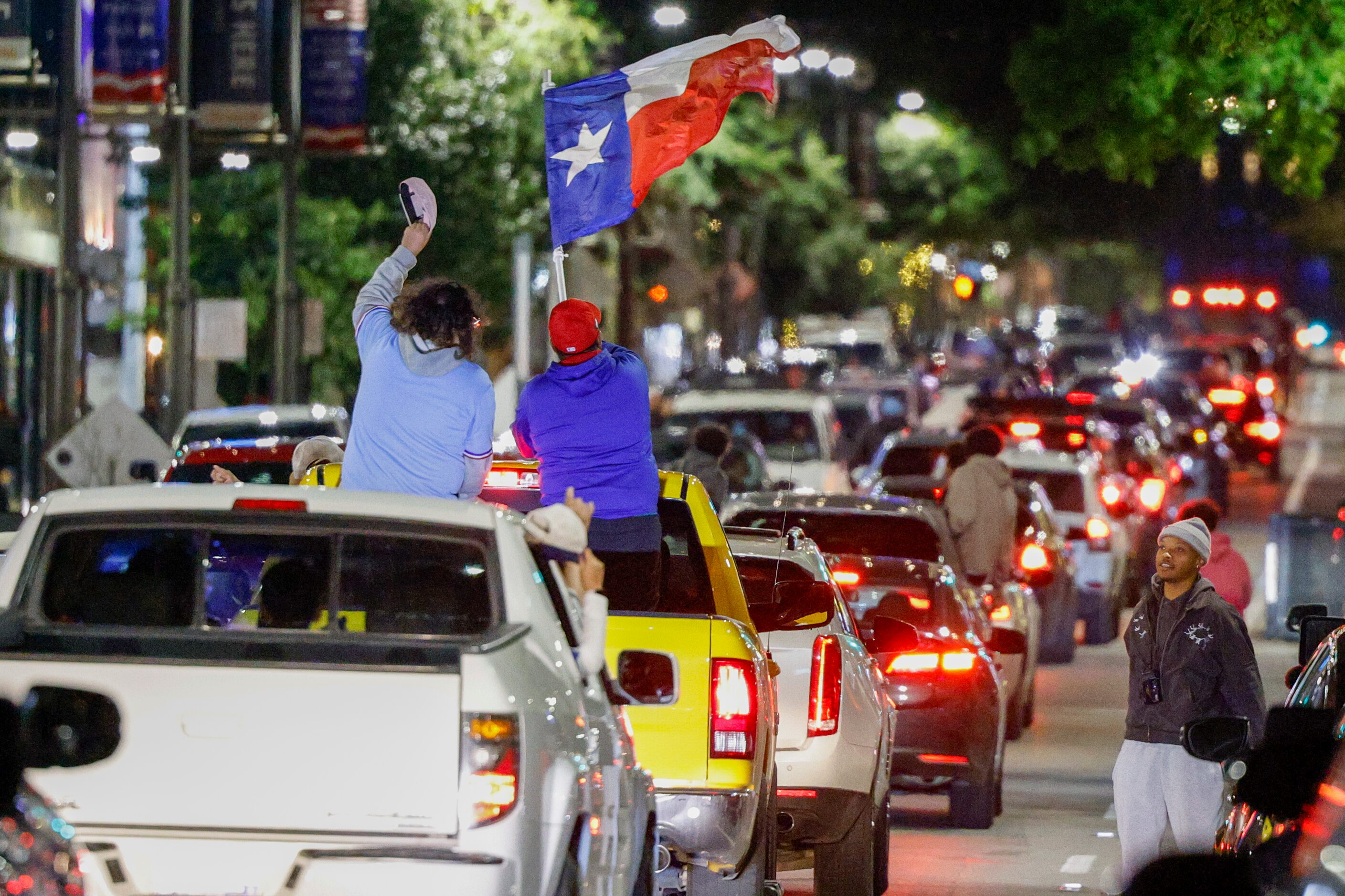 A man waves a Texas flag as people celebrate the Texas Rangers World Series championship on...