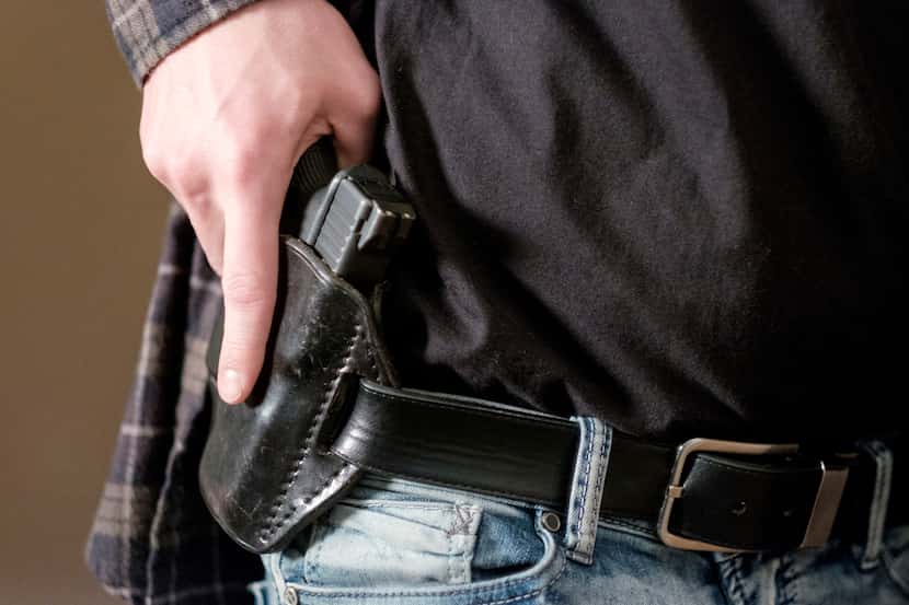 Un hombre porta una pistola en una funda al descubierto.