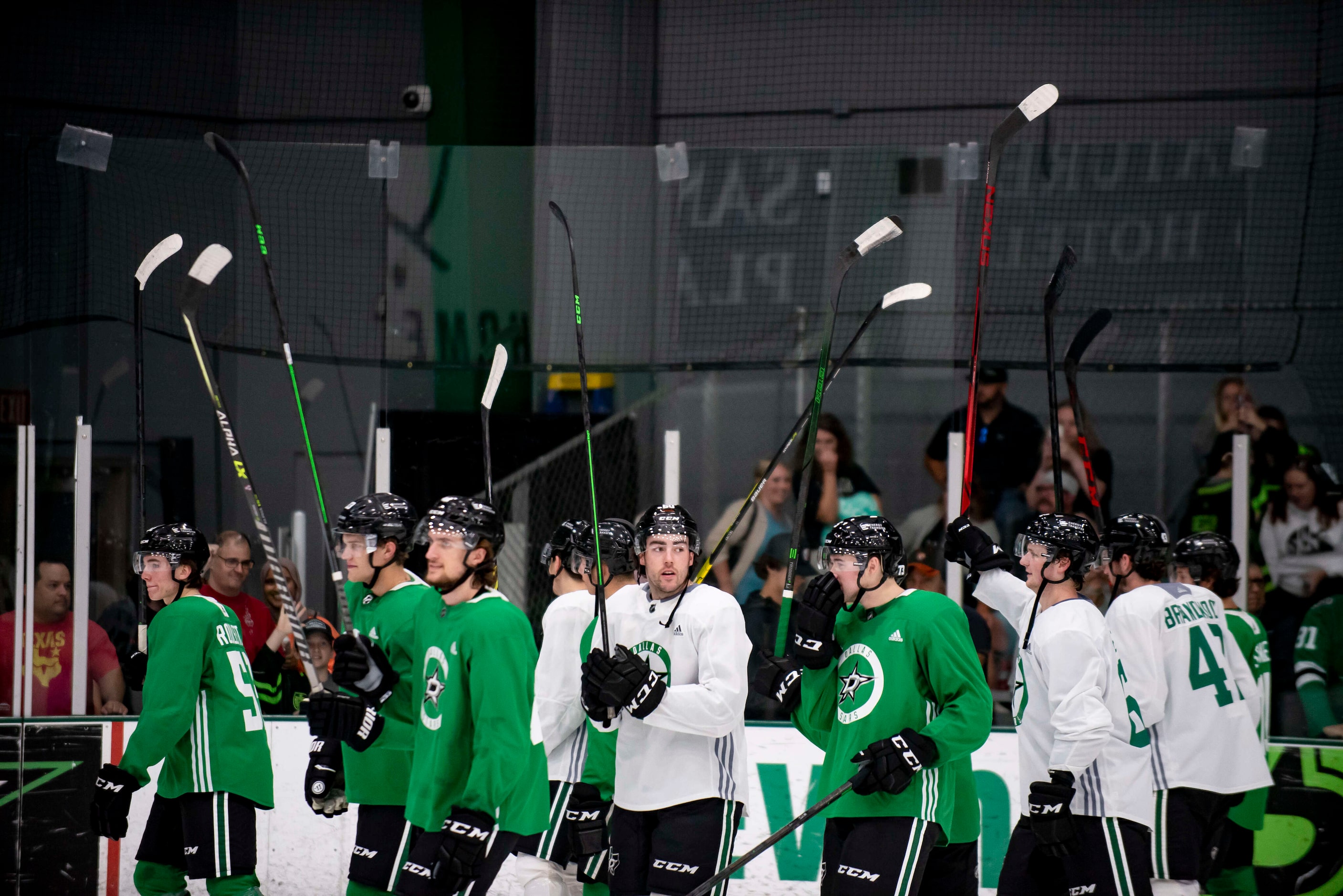 Players raise their sticks in acknowledgement of the fans following the 2022 Dallas Stars...