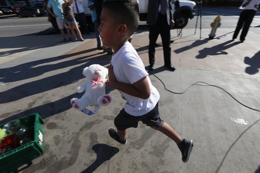 Aaron Chavez, 6, runs to put a teddy bear in the archive as librarians from the Dallas...