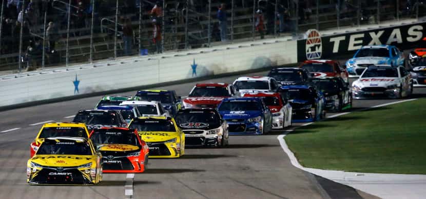 Carl Edwards (19) leads the pack of cars during Duck Commander 500 at Texas Motor Speedway...