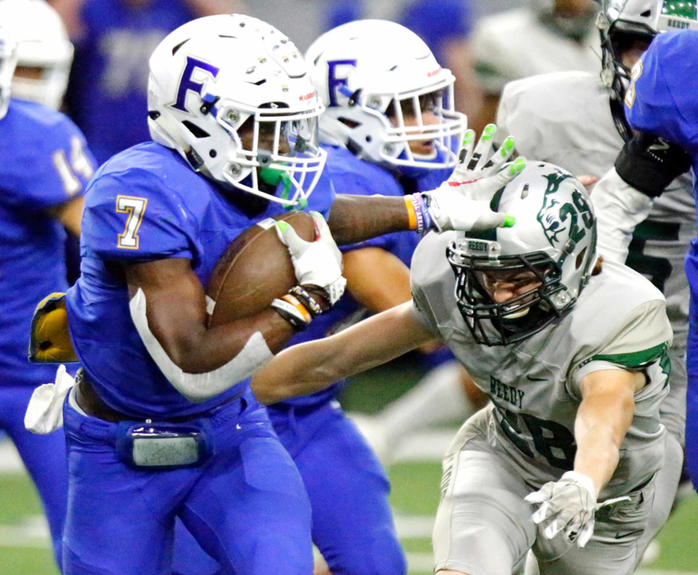 Frisco High School running back Bryson Clemons (7) gives a stiff arm to Reedy High School...