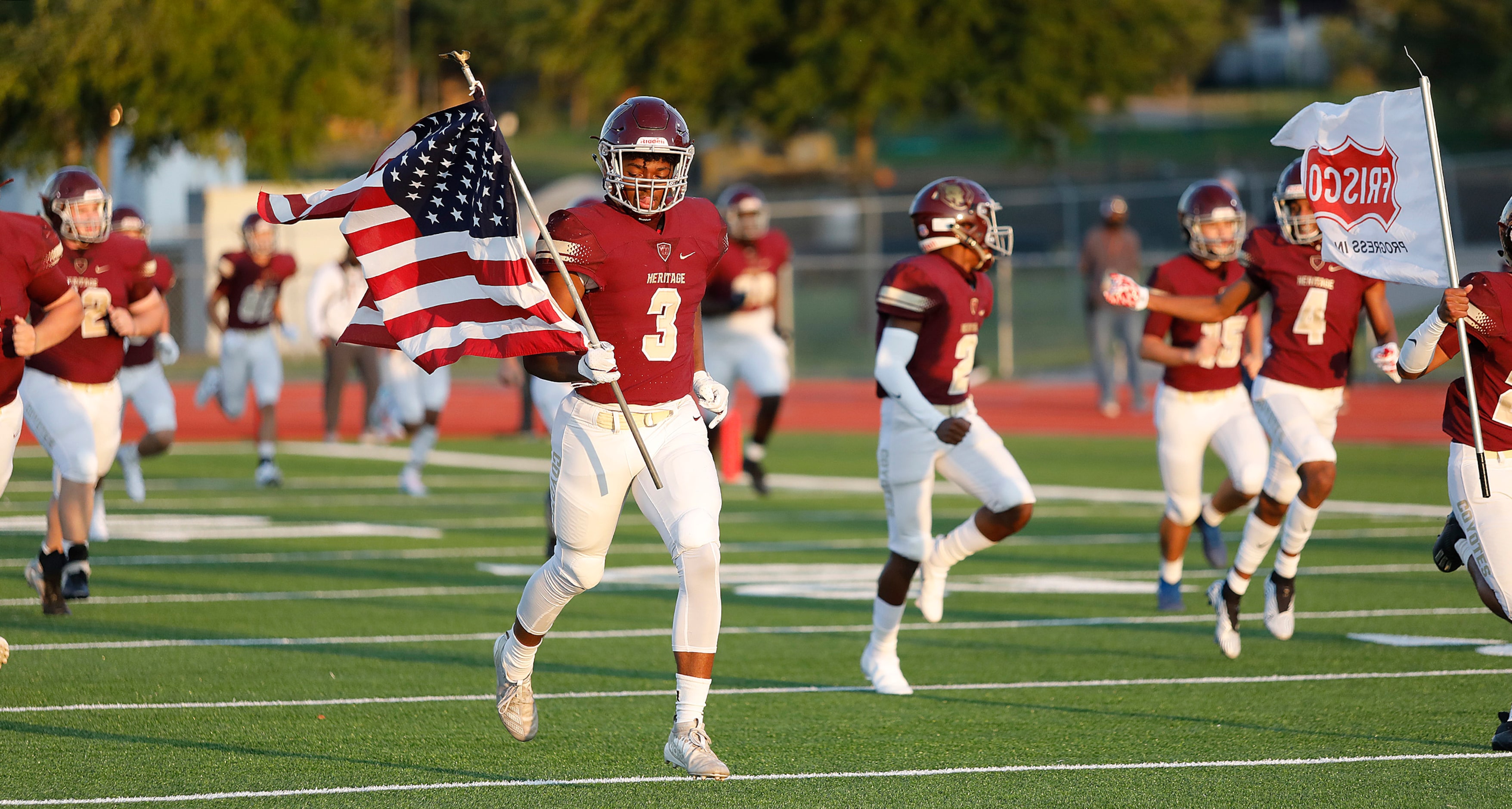 Heritage High School wide receiver Jordan Gregory (3) carries the United States flag as the...