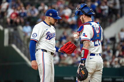 Texas Rangers starting pitcher Nathan Eovaldi takes the ball from catcher Jonah Heim after...