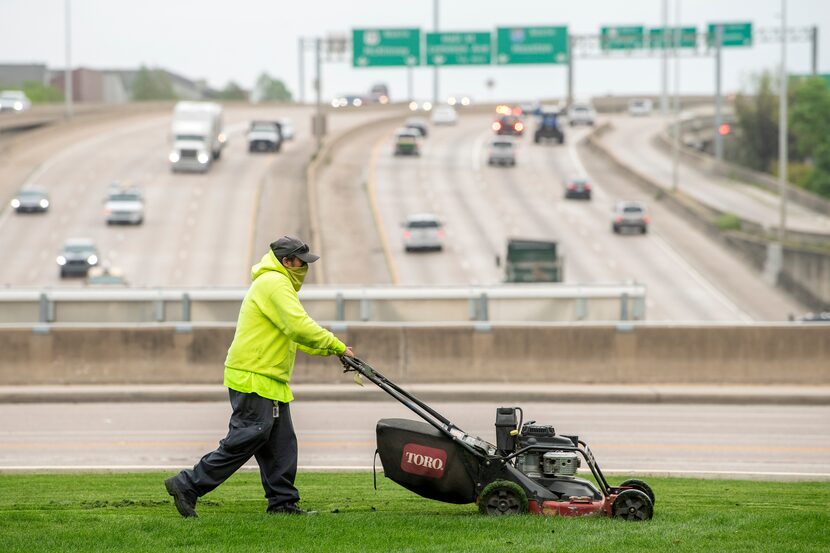 Saul Vasquez, a landscaper with Southern Botanical, mows the grass at Klyde Warren Park.