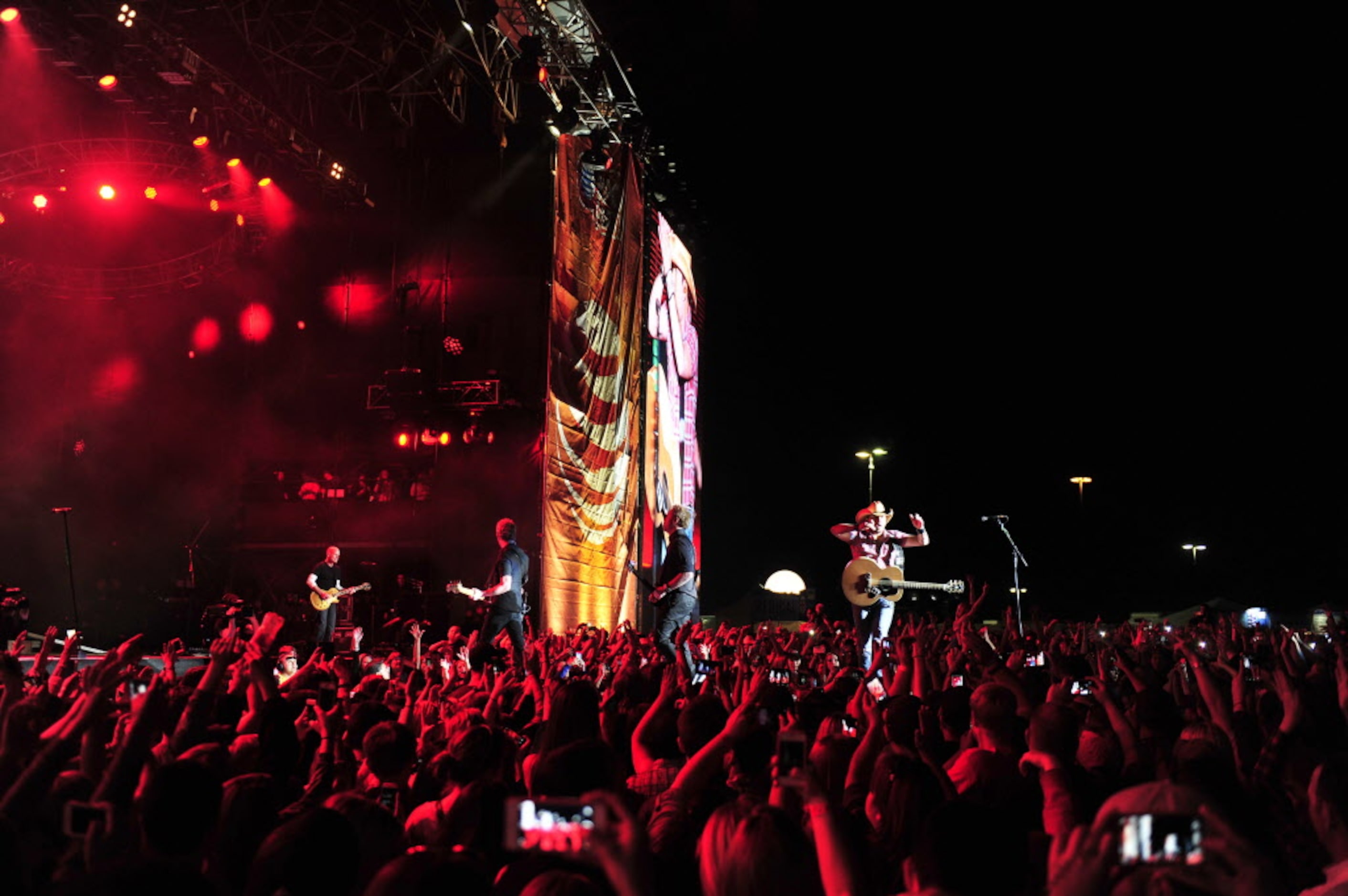 Jason Aldean (right on stage) and his band perform live at the 2014 NCAA March Madness Music...