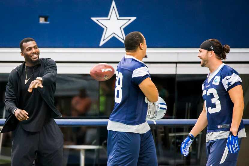 Dallas Cowboys wide receiver Dez Bryant tosses a ball toward defensive tackle Tyrone...