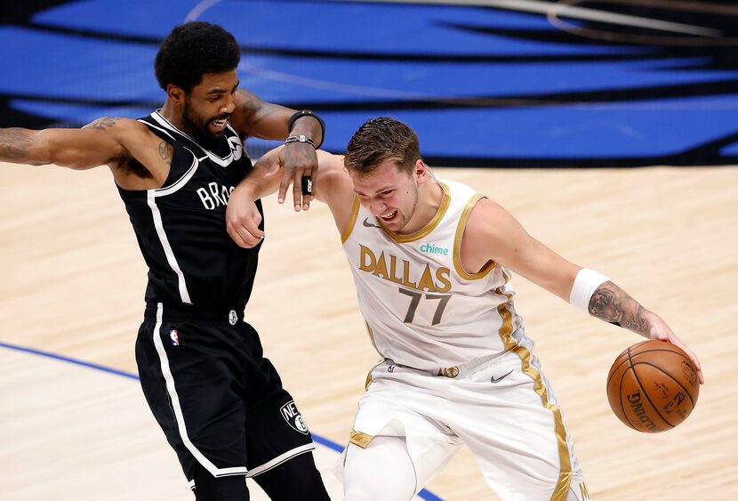 Dallas Mavericks guard Luka Doncic (77) forces his way past Brooklyn Nets guard Kyrie Irving...