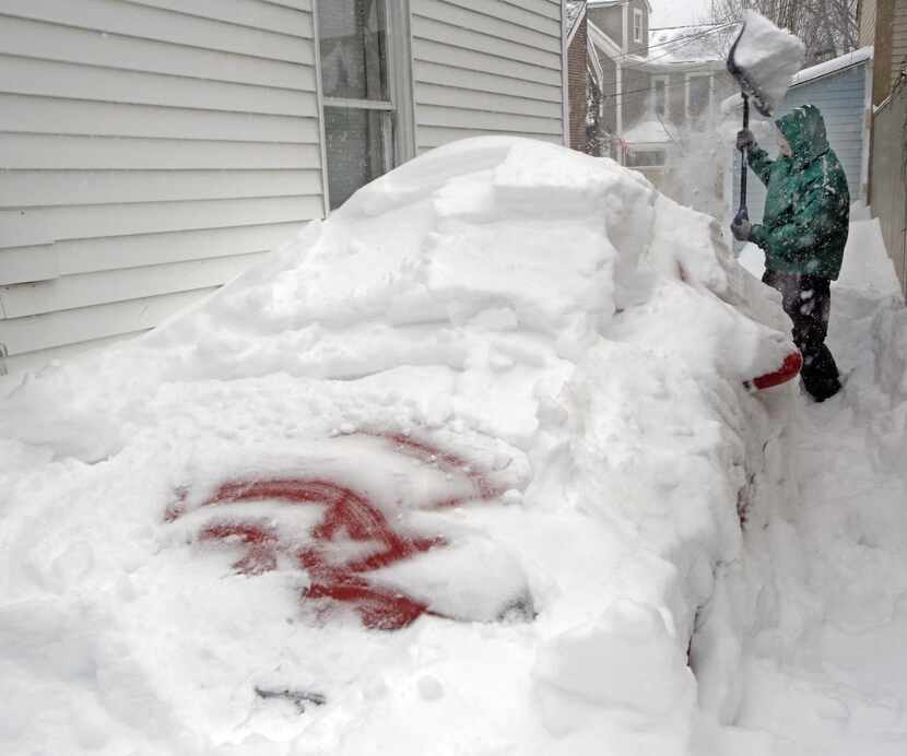 
Peter Urquhart works to clear his car of snow in Portsmouth, N.H. In some areas of the...