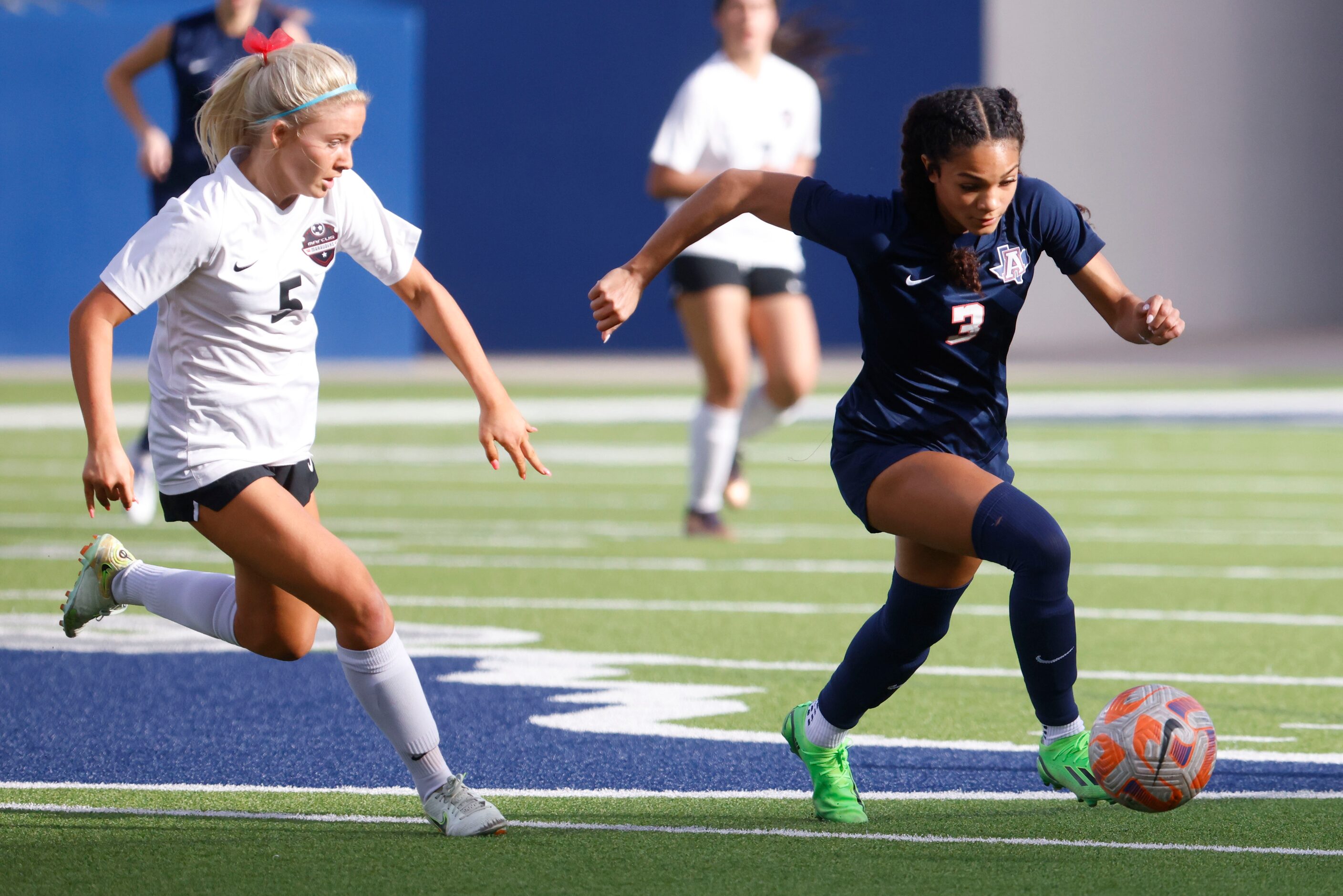 Allen’s Ava McDonald (right) runs past Marcus’ Savannah Wylie during the first half of a...