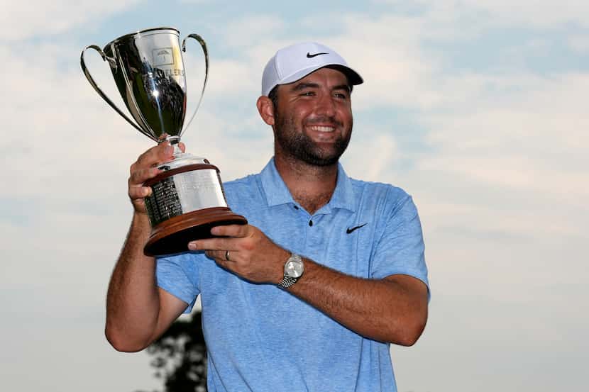Scottie Scheffler holds up his trophy after winning the Travelers Championship golf...