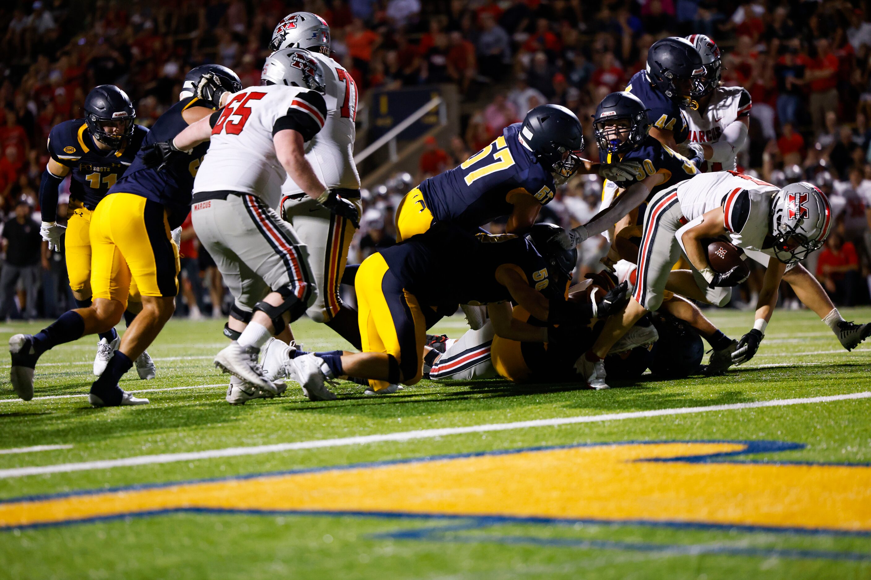 Flower Mound Marcus running back Chance Banner (27) breaks through the Highland Park...