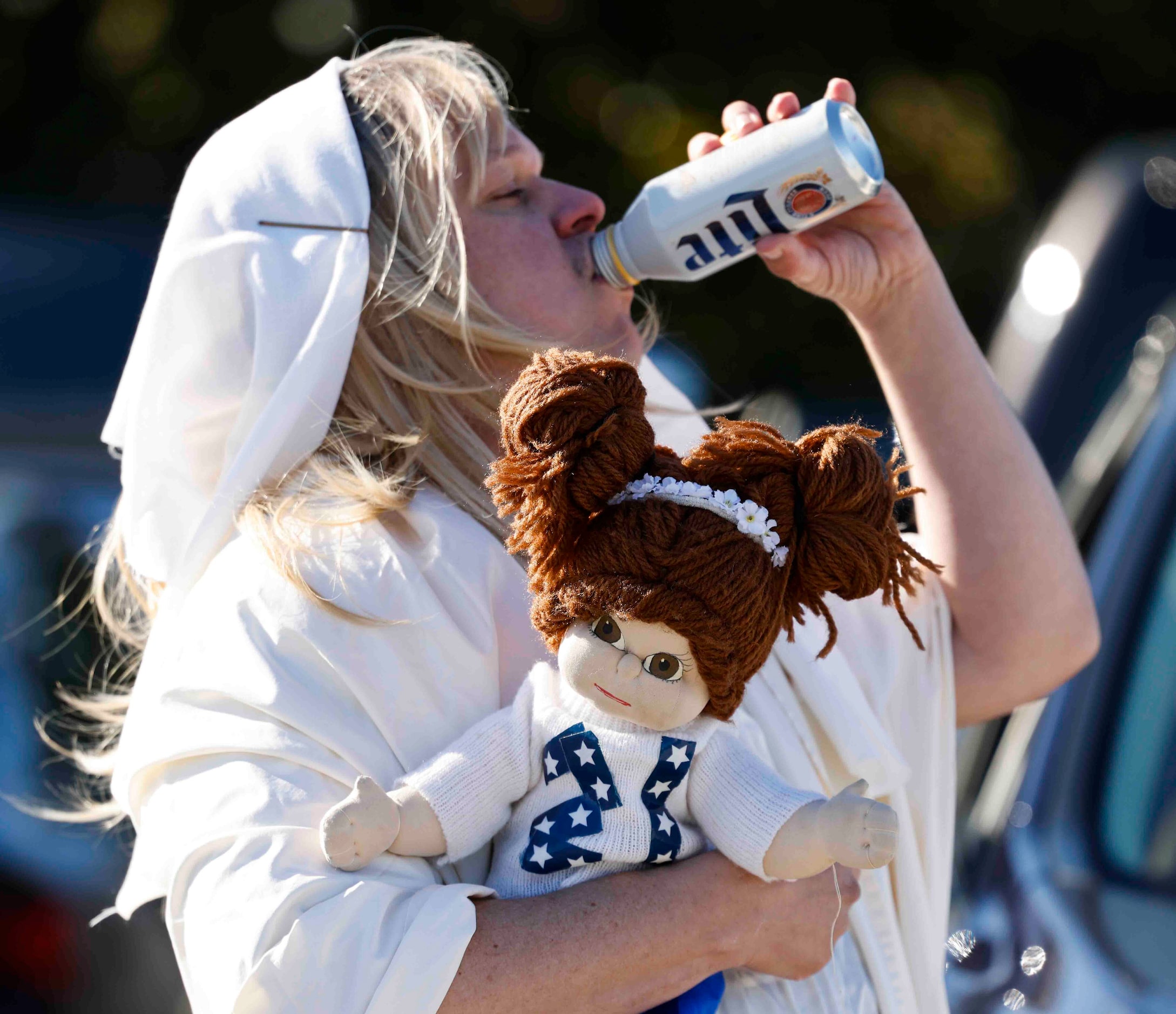 Jacob Wilson holding a doll lookalike Ezekiel Elliott gets a drink as he tails gaits ahead...