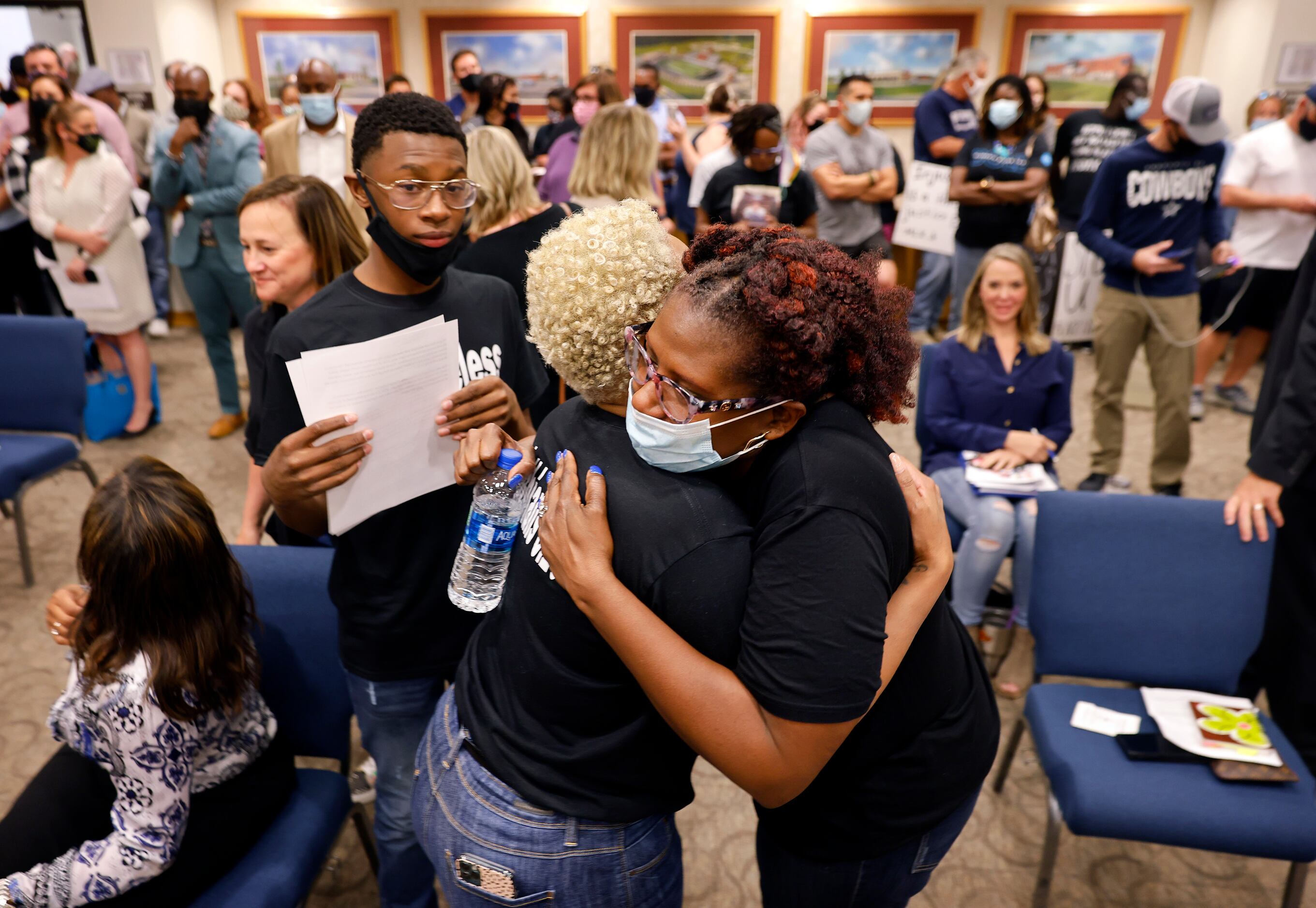 Patrel Bryant (right), a parent of two students, gives a supportive hug to Mioshi Johnson,...