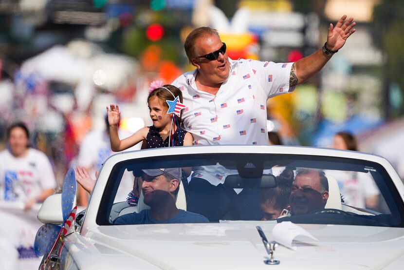 Arlington mayor Jim Ross waves from a convertible during the Arlington Independence Day...