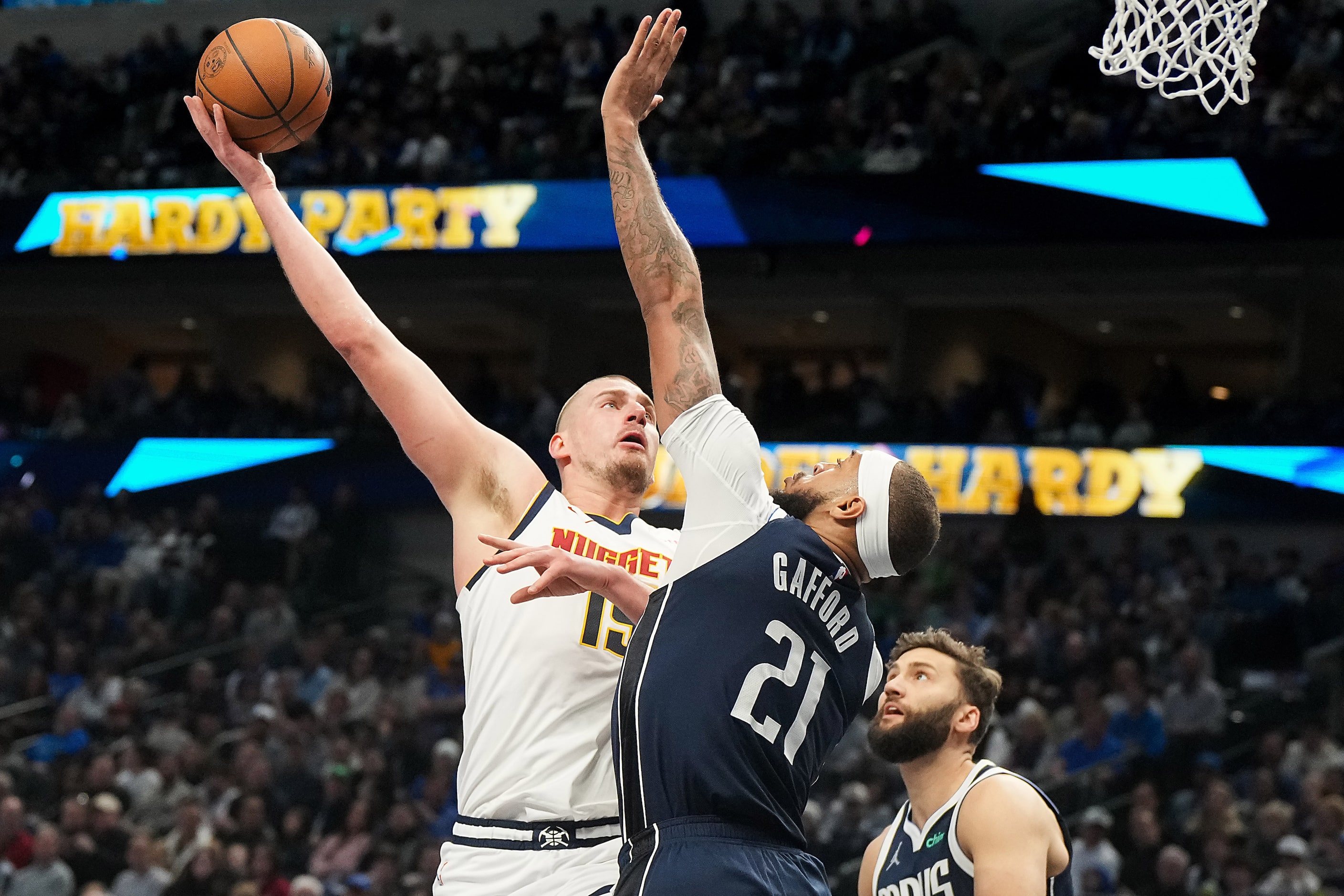 Denver Nuggets center Nikola Jokic (15) scores over Dallas Mavericks center Daniel Gafford...