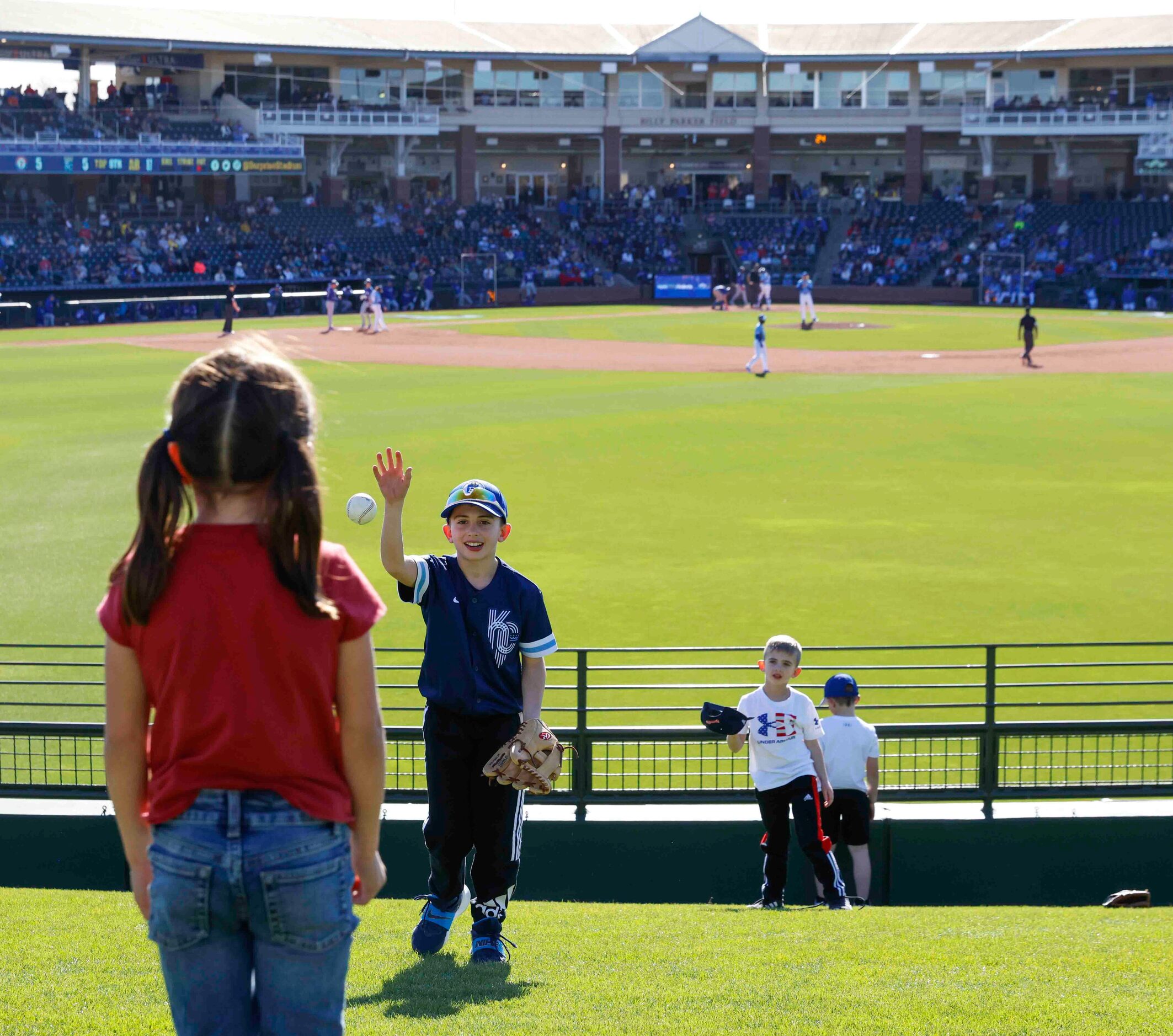 Gavin Edwards, , 10, center, throws a ball to Kyla Council, 8, left, as Davis Edwards, 6,...