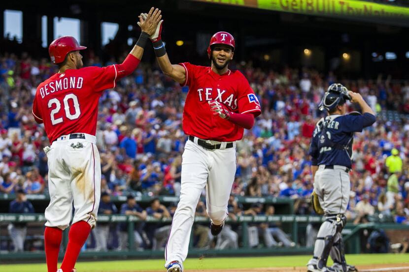 Texas Rangers left fielder Ian Desmond (20) and right fielder Nomar Mazara (30) high-five...