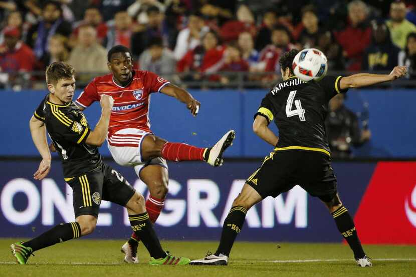 FC Dallas forward Fabian Castillo (11) shoots the ball by Columbus Crew midfielder Will...