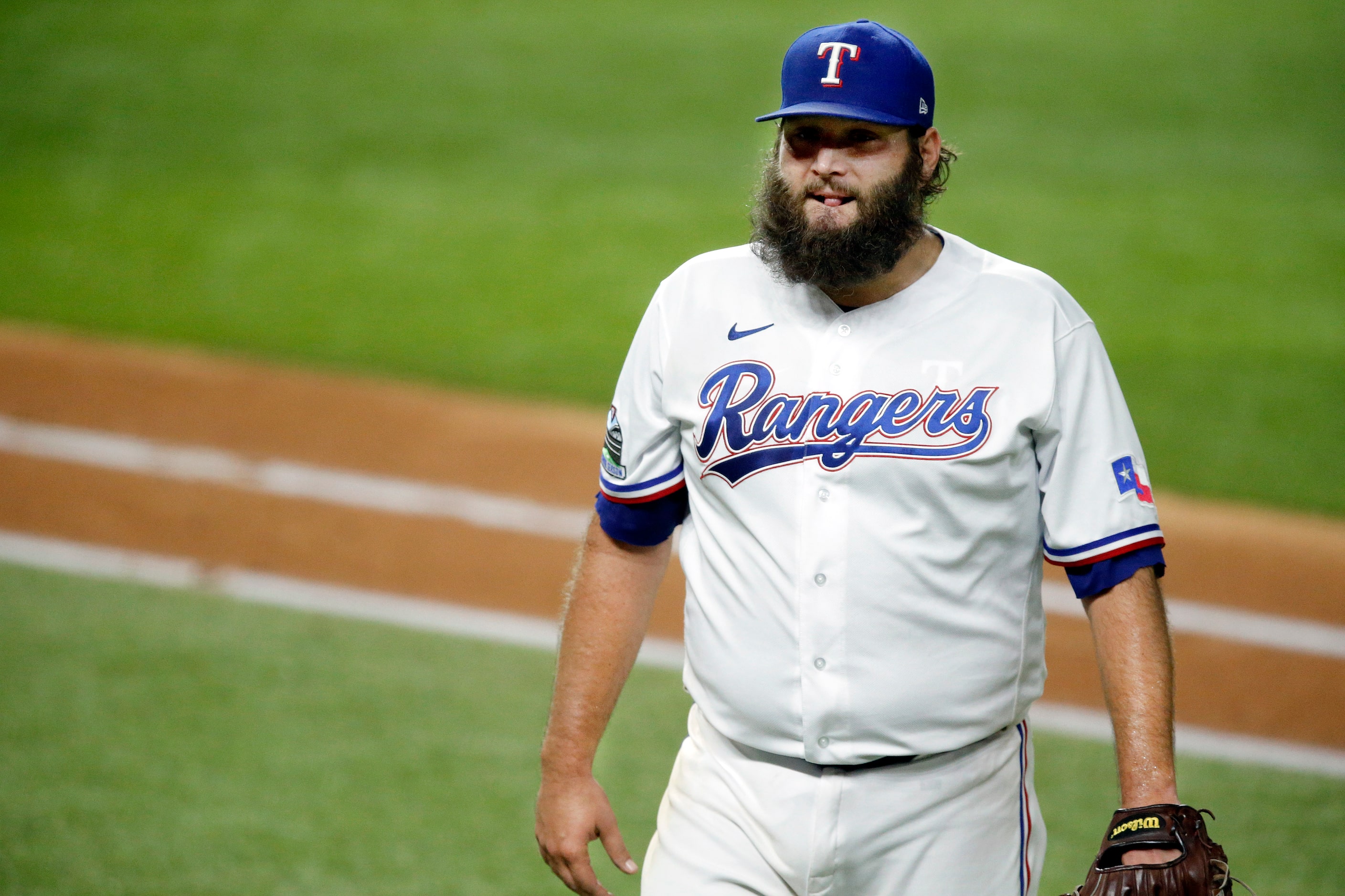 Texas Rangers starting pitcher Lance Lynn (35) walks off the field after pitching the sixth...