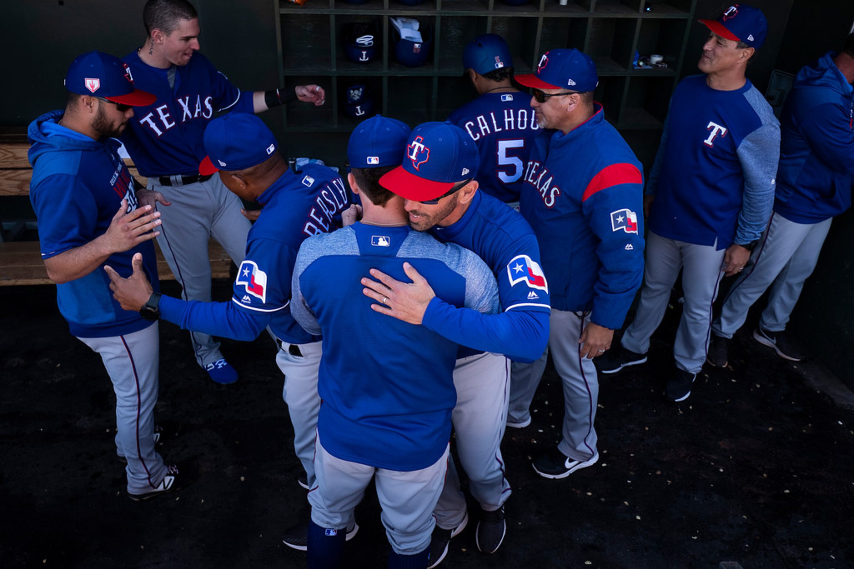 Texas Rangers manager Chris Woodward hugs infielder Nolan Fontana before a spring training...