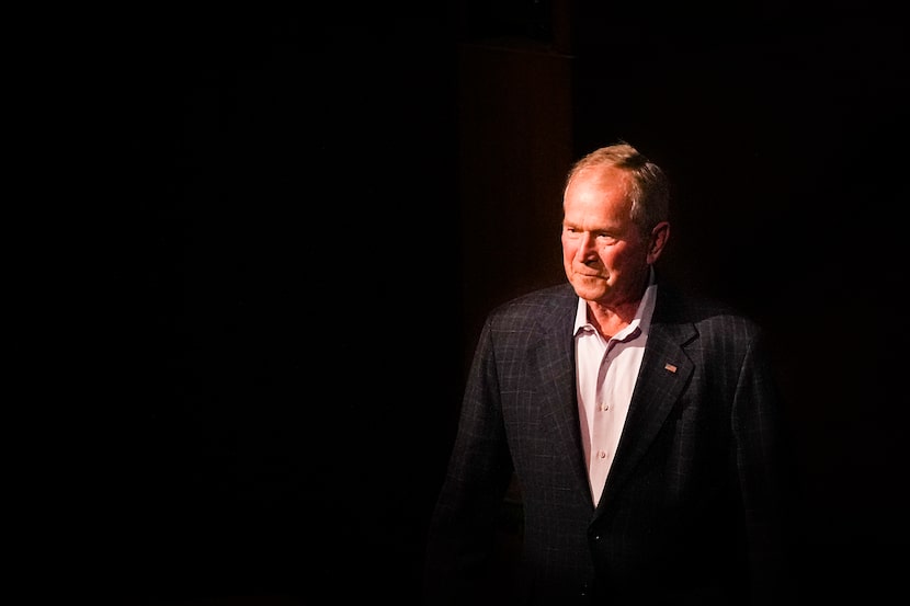 Former President George W. Bush steps away from the podium after delivering his remarks. As...