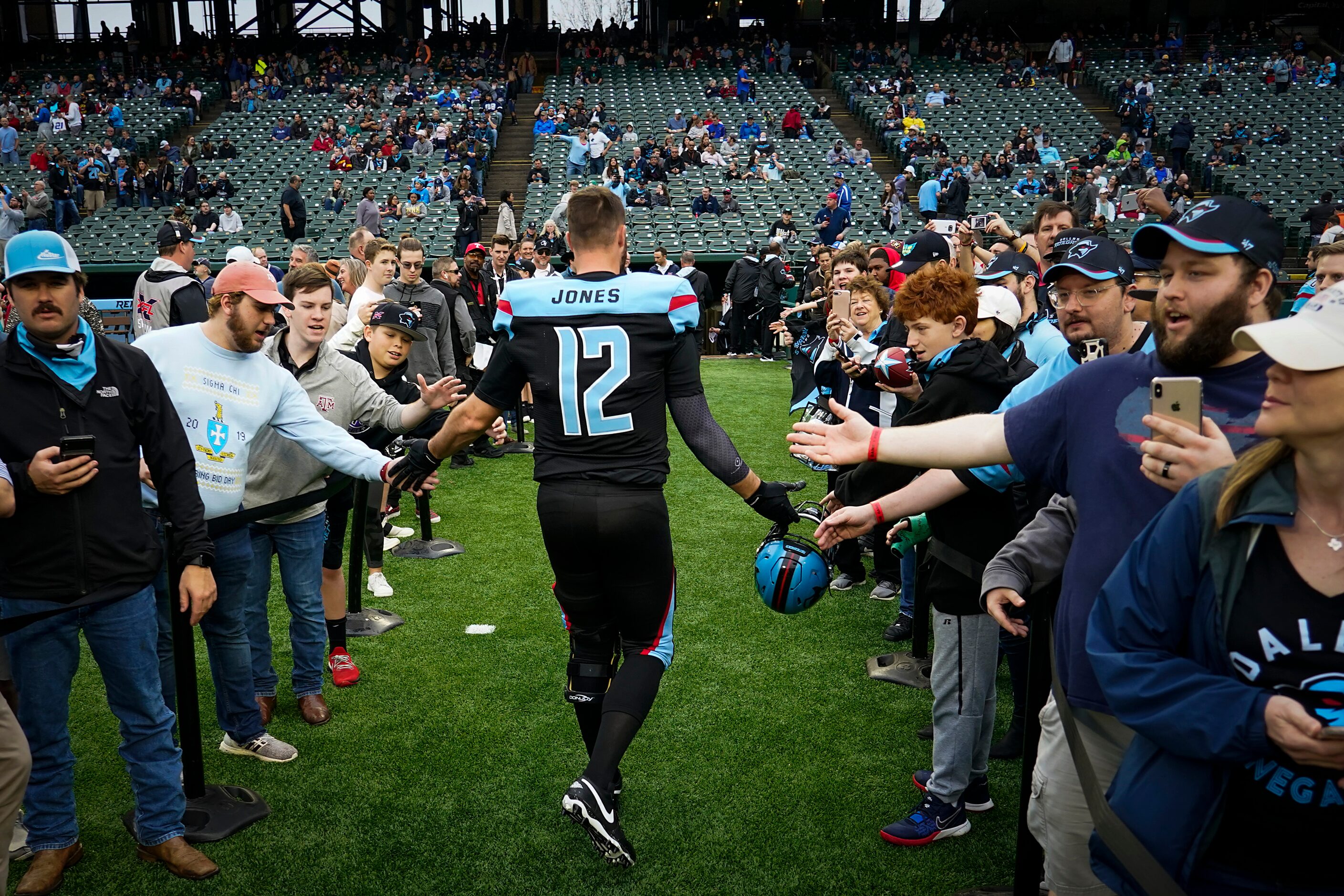 Dallas Renegades quarterback Landry Jones (12) high fives fans before an XFL football game...