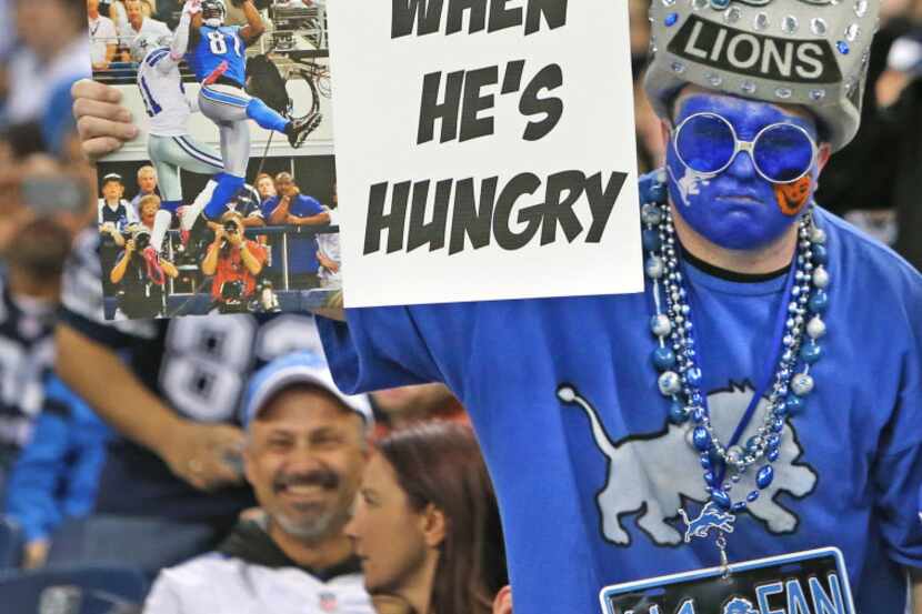A Lions fan holds a sign comparing Dez Bryant and Calvin Johnson during the Dallas Cowboys...