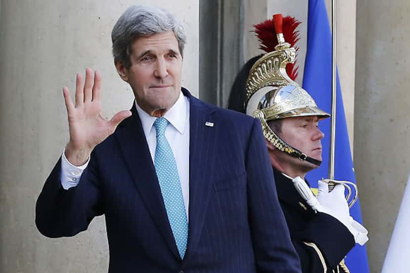 U.S. Secretary of State John Kerry waves to the media Wednesday as he arrives for a meeting...