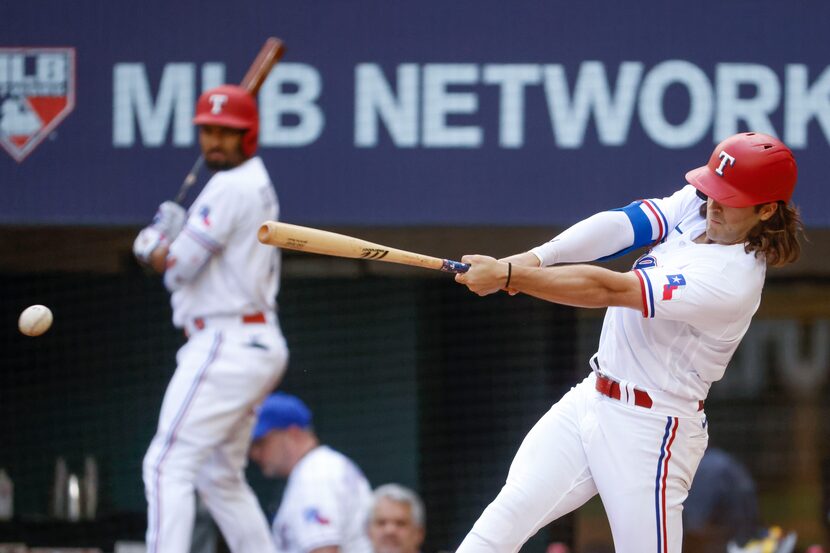 Texas Rangers shortstop Josh Smith hits as he singles on a ground ball during the second...