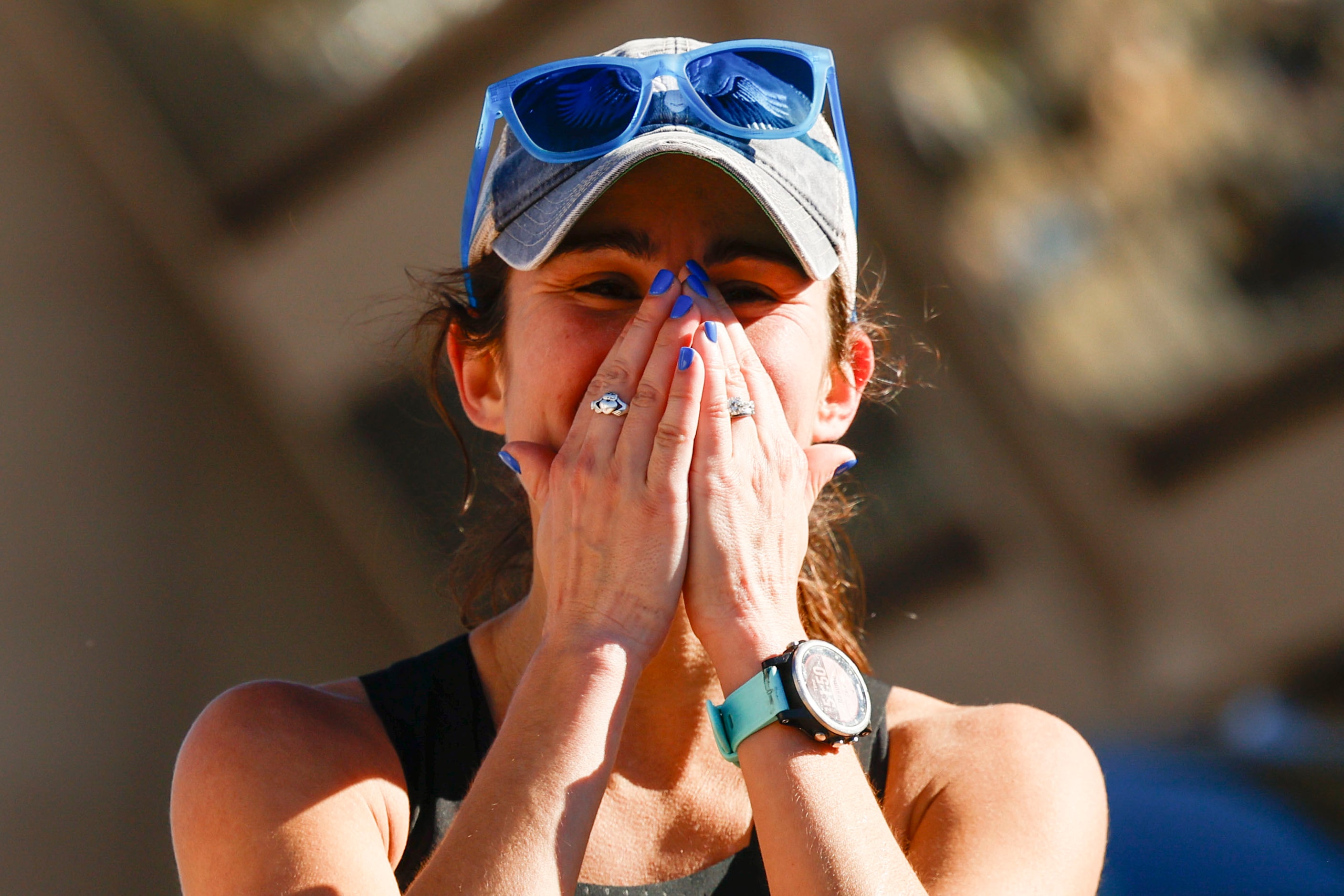 Women’s marathon finisher Jill Wolf, of Dallas, celebrates after reaching the finish line...