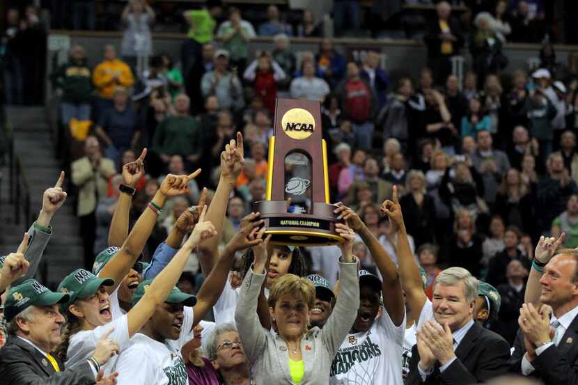 Head coach Kim Mulkey of the Baylor Bears holds up the National Championship trophy as she...