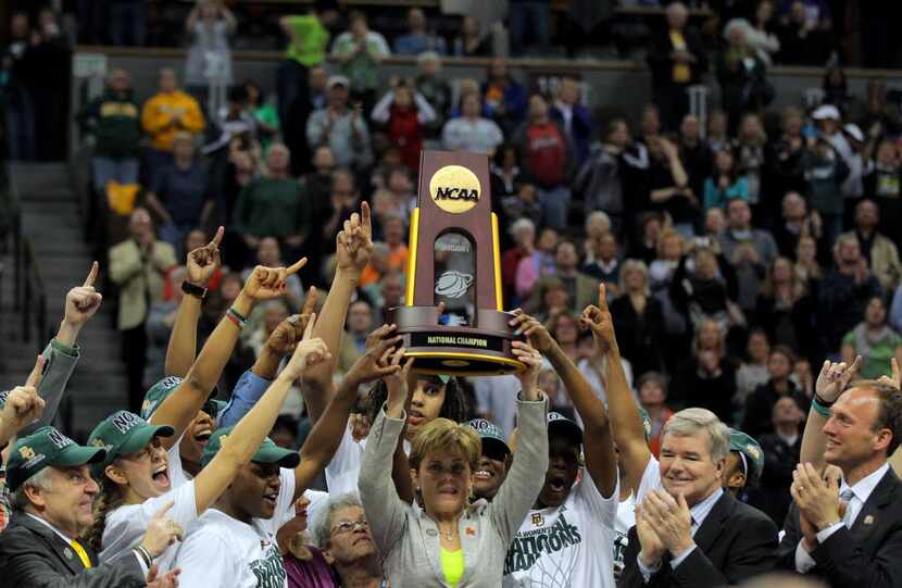 Head coach Kim Mulkey of the Baylor Bears holds up the National Championship trophy as she...