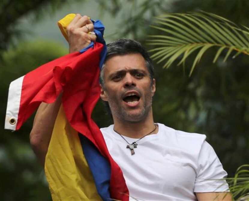 El líder opositor venezolano Leopoldo Lopez sostiene una bandera nacional ante su casa en...