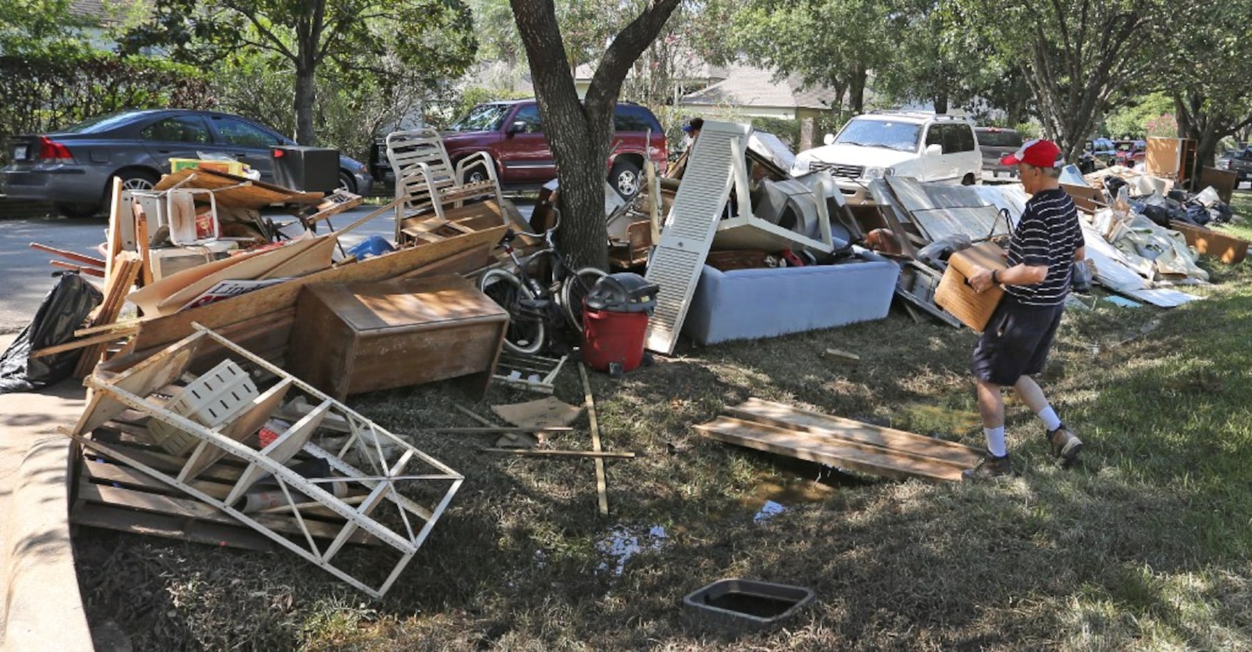 Arthur Storey carries waterlogged personal items to the curb in the Memorial Drive Acres...