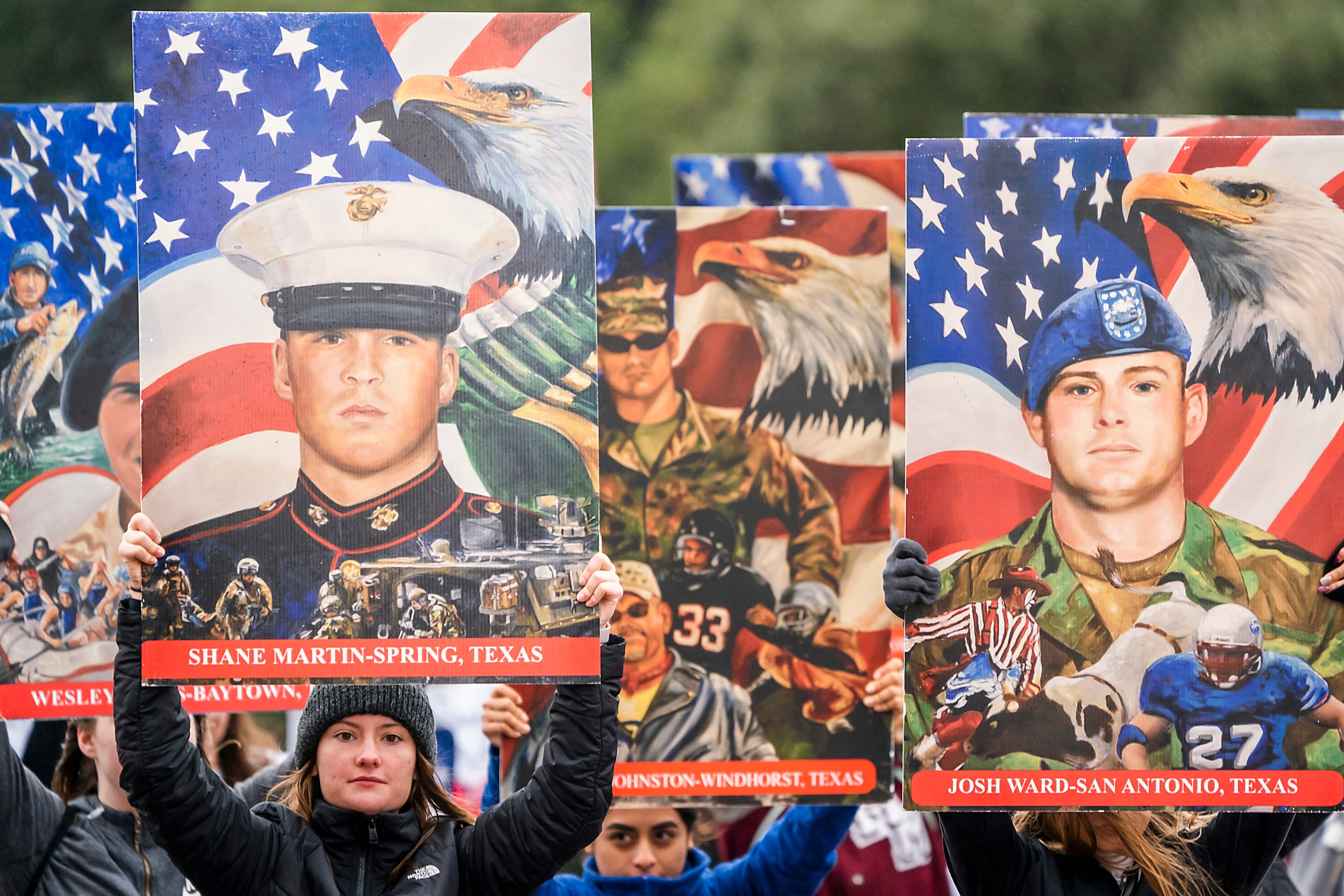 The MartinÕs Mill High School ÒTexas Platoon of the FallenÓ hold up images of fallen service...