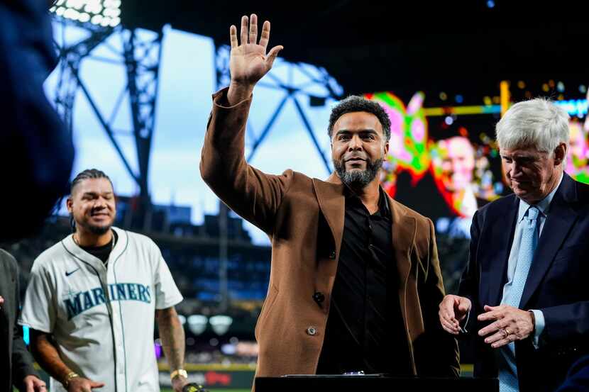 Former Seattle Mariners player Nelson Cruz waves after signing a one-day contract to retire...