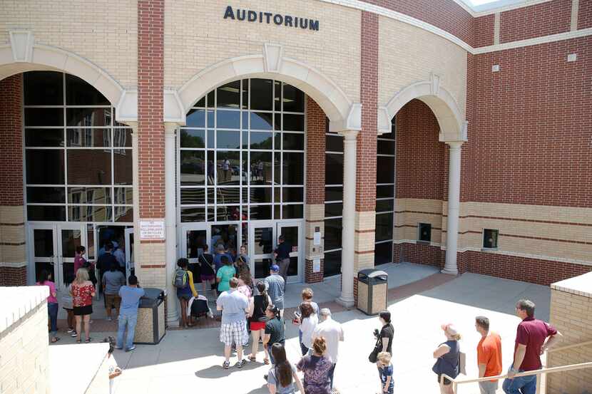 McKinney North High School parents wait in line to pick up students as a line forms at...
