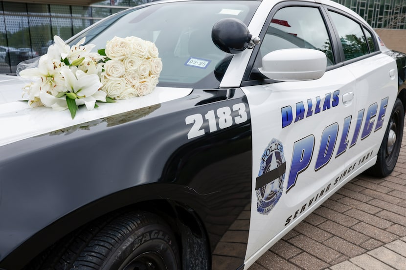 A Dallas police patrol car is set up as a memorial outside of the south central station with...