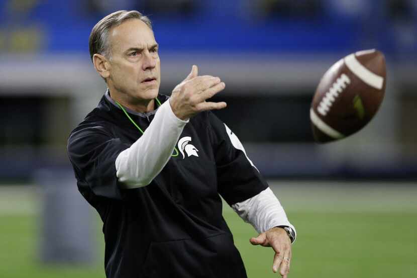 Michigan State head coach Mark Dantonio tosses a ball during team practice for the NCAA...