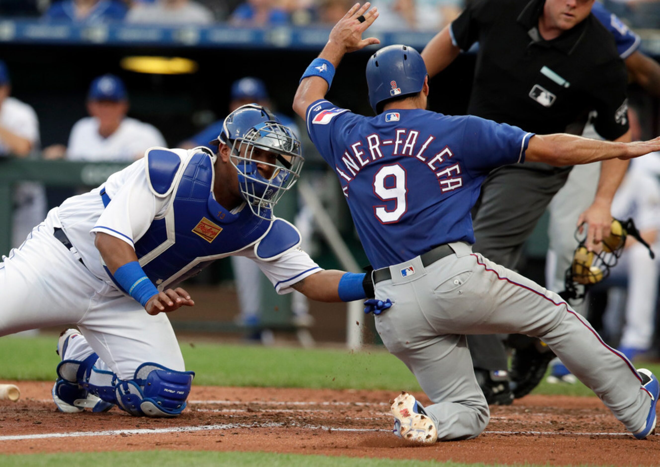 Kansas City Royals catcher Salvador Perez, left, tags out Texas Rangers' Isiah Kiner-Falefa...