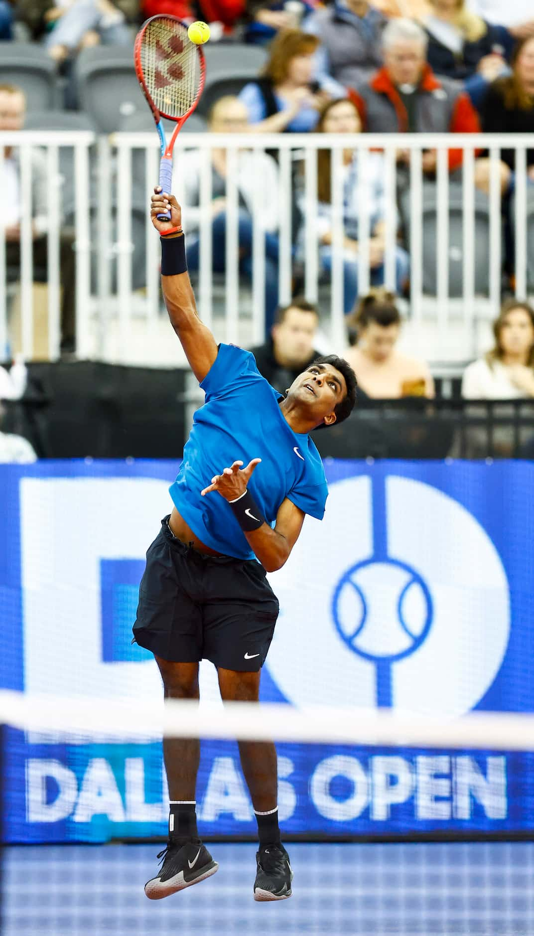 SMU senior Caleb Chakravarthi serves the ball in a match against Vasek Pospisil during the...