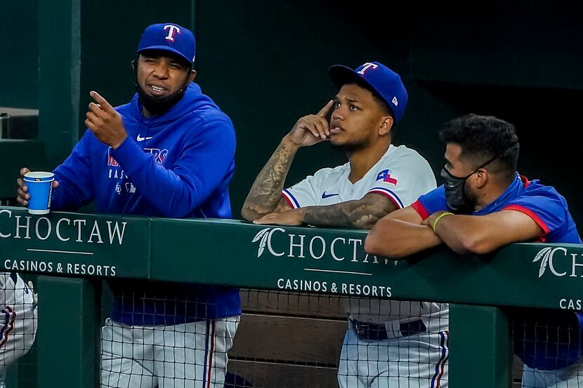 Texas Rangers shortstop Elvis Andrus (left) watches from the dugout with outfielder Willie...