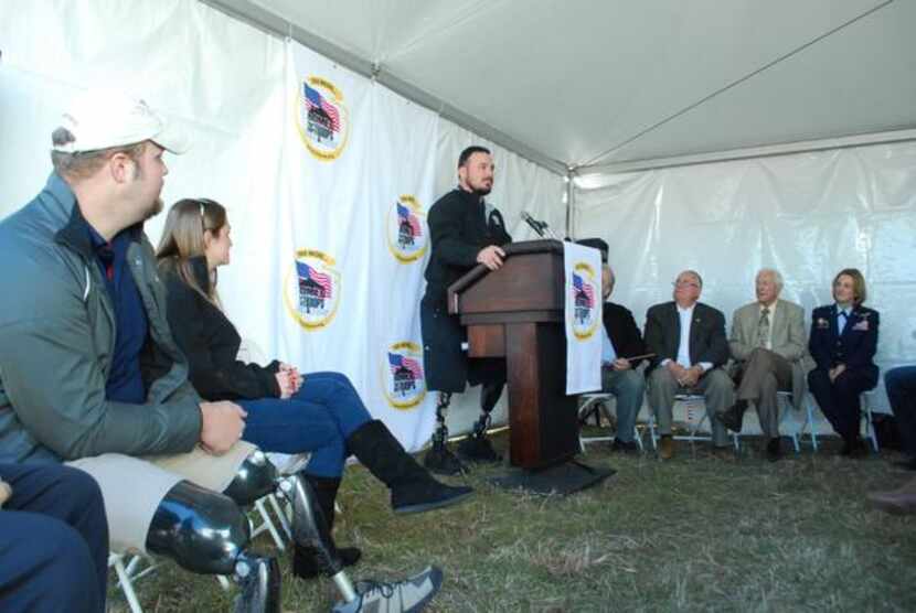 Marine Cpl. Michael Fox speaks before a crowd gathered at a groundbreaking for his new home...